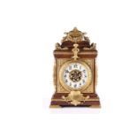 An early 20th century French 8-day oak cased mantle clock of architectural form with gilt metal
