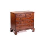 A George III mahogany chest of two short over three long drawers with swan neck handles. On shaped