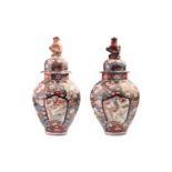 A pair of Japanese Imari porcelain vases and covers, Edo, of octagonal form, the domed covers