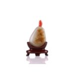 A Chinese jade pebble shape snuff bottle, 20th century, of pear form with a coral stopper, the stone