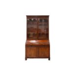 A George IV mahogany cylinder bureau bookcase. the upper section with a pair of plain glazed doors
