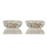 A pair of Chinese porcelain shallow bowls, each painted with figures in boats before buildings and