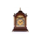 An early 20th-century German 8-day mantle clock with mahogany broken arch case with angel