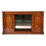 A Victorian figured burr walnut low bookcase with a central mirror back alcove flanked by a pair