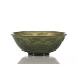 A Mughal style spinach jade bowl, with slightly everted rim, the exterior carved in relief with