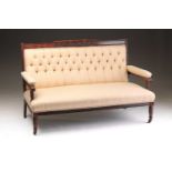 An Edwardian solid figured rosewood two-seat settee with channelled and floral carved show frame and