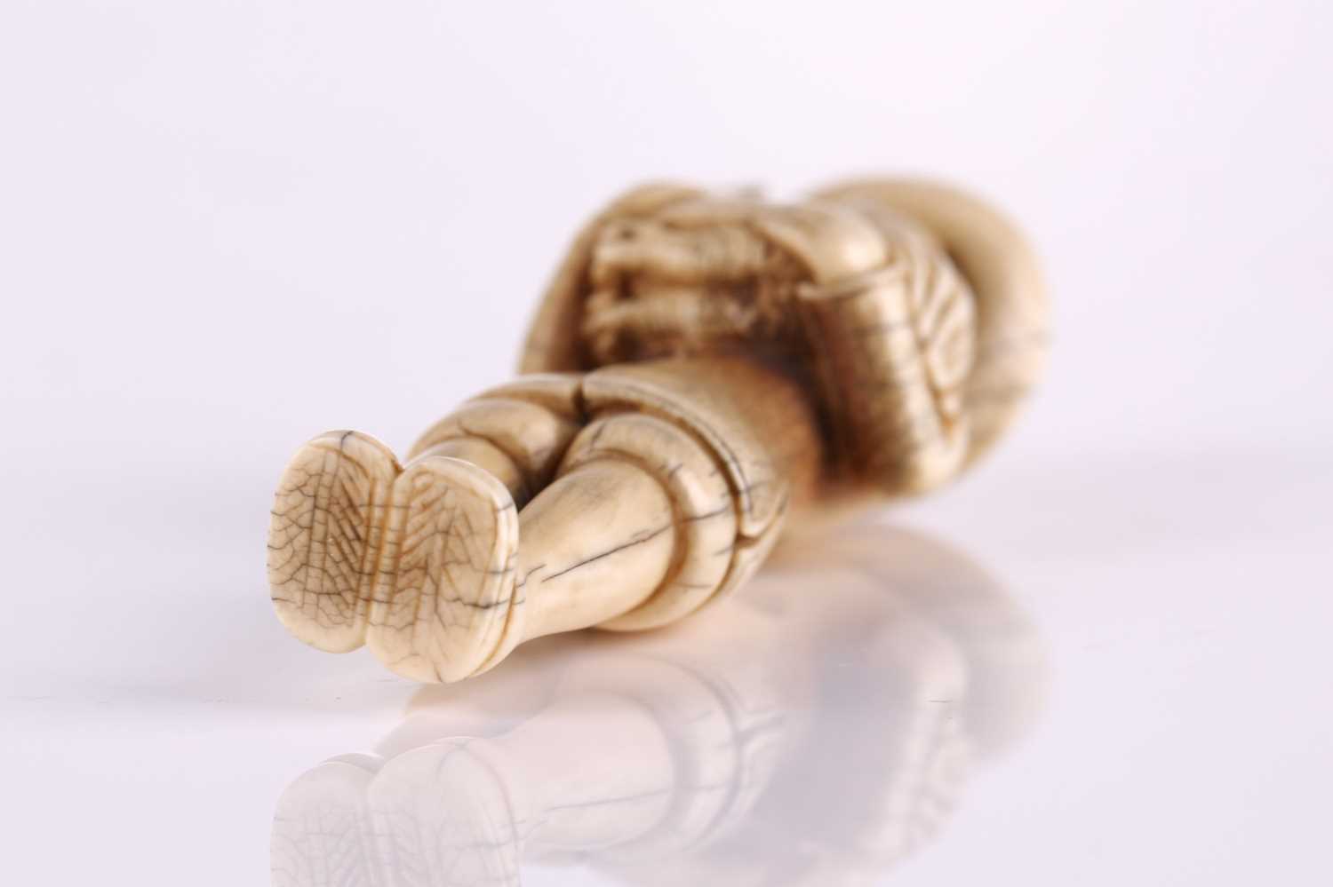 A Japanese ivory netsuke of a standing Dutchman holding a large cockerel, Edo or later, wearing a - Image 2 of 3