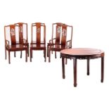 A 20th-century Chinese padouk wood extending circular dining table with single leaf insert and six