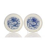 A pair of Chinese blue & white dragon dishes, each painted with a dragon writhing amongst fiery