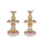 A pair of Chinese famille rose and yellow ground candlesticks, painted with lotus flowers and