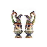 A pair of late 19th century Continental majolica glazed pottery ewers moulded in high relief with