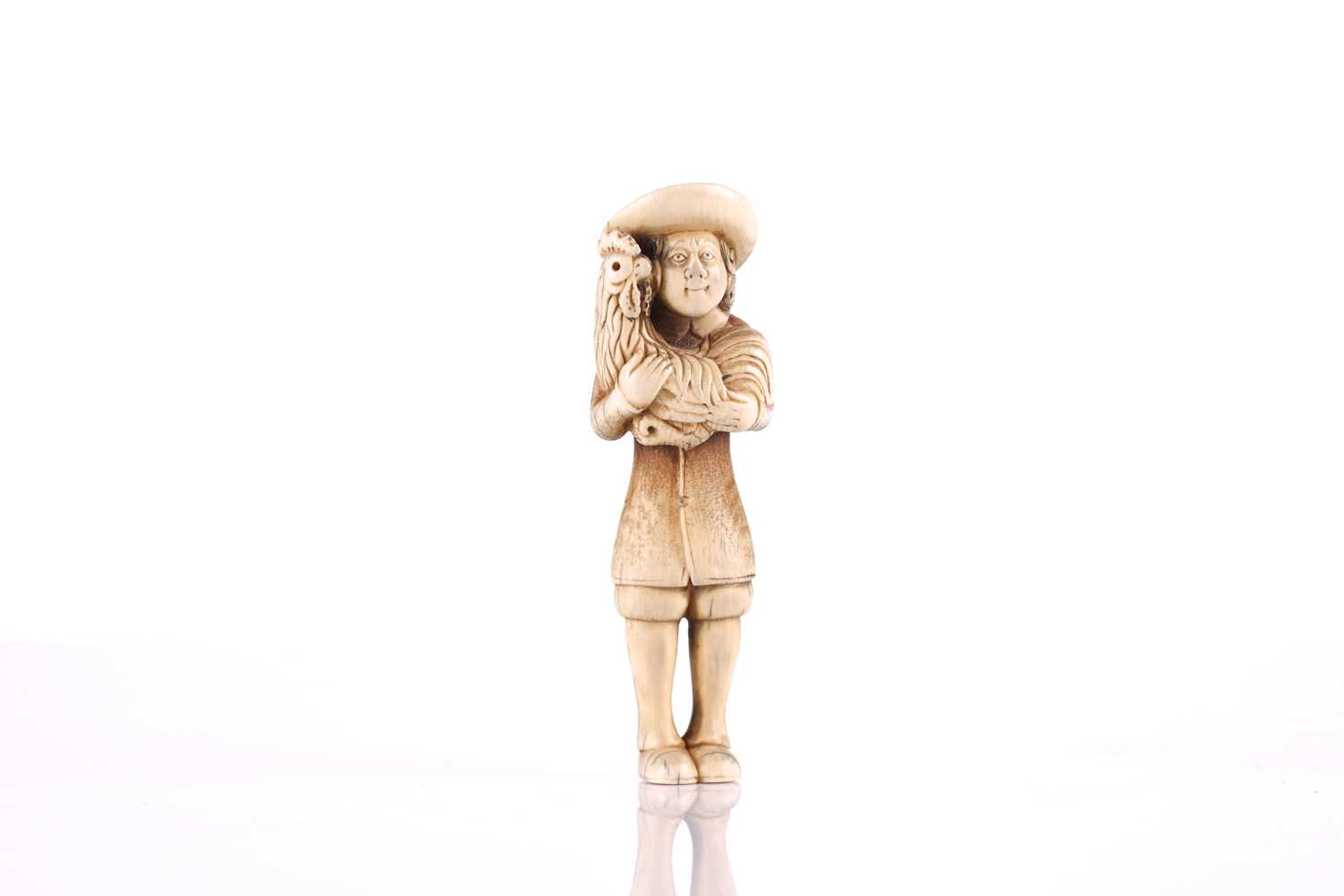 A Japanese ivory netsuke of a standing Dutchman holding a large cockerel, Edo or later, wearing a