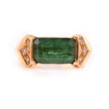 An emerald and diamond ring, comprises a deep green coloured emerald with sub translucent