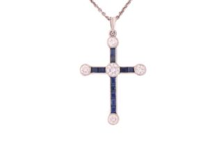 A diamond and sapphire cross pendant on platinum chain, featuring five round brilliant diamonds with