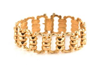 A fancy link bracelet in yellow precious metal, with stylised links adjoined to a tongue and