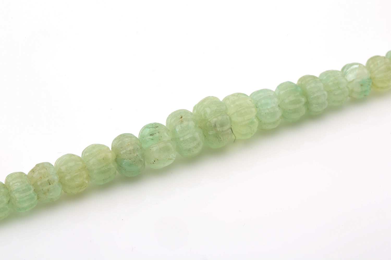 A carved emerald bead necklace, comprising a string of ninety-one reeded emerald beads in pale green - Image 3 of 5