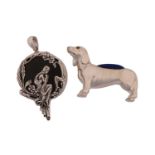 A 20th-century white metal novelty Dachshund pin cushion with inset glass eyes. 5 cm long.
