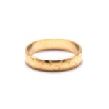 An 18ct gold textured wedding ring, with a D-profile band, London hallmarked with sponsor's mark '