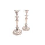 A pair of early 20th century loaded silver table candlesticks with segmental bodies and on spreading