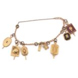 A yellow metal bracelet with assorted college fraternity charms, some of the charms are marked