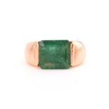 An emerald dress ring, featuring a deep green coloured emerald with sub-translucent transparency,