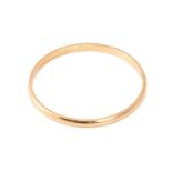 A yellow precious metal closed bangle, with a solid D-profile band, marked as '18ct OBLO', inner