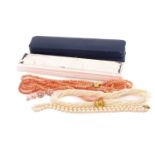 A lot consists of two pearl necklaces, one coral bead necklace and two pairs of pearl earrings;