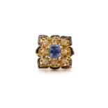 A sapphire and diamond cluster ring, the cushion mixed cut sapphire with pale cornflower blue body