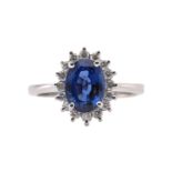 A sapphire and diamond halo ring, featuring oval mixed cut sapphire with intense blue body colour,