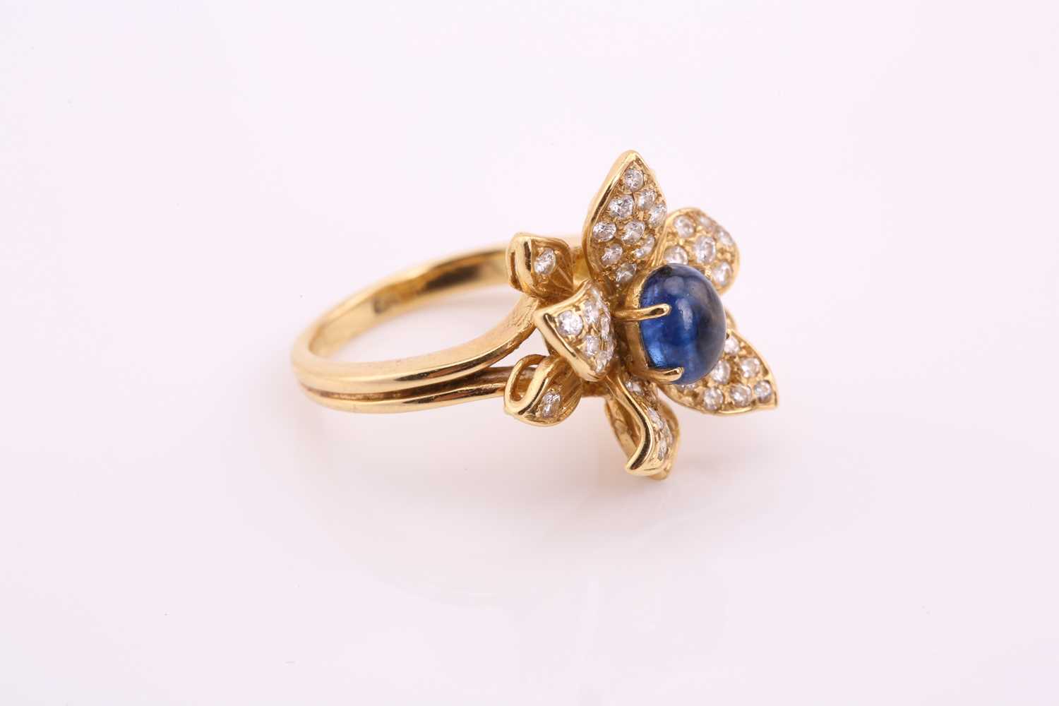 An 18ct gold sapphire and diamond flower ring, comprises an oval sapphire cabochon with a high dome, - Image 2 of 4
