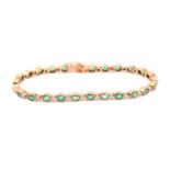 An emerald and diamond bracelet in yellow precious metal, each individual link is collet set with an