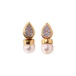 A pair of pearl and diamond earrings, each consisting of an 8.5 mm cream coloured pearl with pink