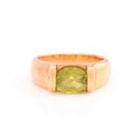 A peridot ring, featuring an oval mixed-cut peridot, approximately measuring 8.2 x 6.7 mm in size,