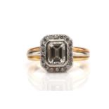 An emerald-cut diamond halo ring, the central stone has an estimated weight of 1.36ct, with