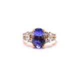 An 18ct bi-coloured gold diamond and tanzanite dress ring, featuring an oval fancy cut tanzanite