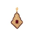 A gem-set arabesque pendant, consisting of an emerald-cut synthetic ruby in the centre, claw set