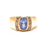 A sapphire and diamond ring, comprises a cushion-cut sapphire with purplish-blue body colour,