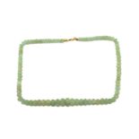 A carved emerald bead necklace, comprising a string of ninety-one reeded emerald beads in pale green