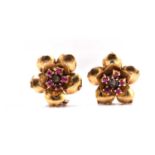 A pair of swivel flower head earrings, each comprising a surmount set with a diamond and five pink