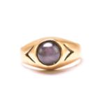 A star sapphire gypsy ring, featuring a round sapphire cabochon with greyish purplish-blue body