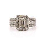 A platinum and diamond entourage ring, featuring an emerald cut diamond in the centre with an