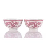 A pair of Chinese porcelain bowls, each painted in pink enamel with a dragon facing a Fenghuang, a
