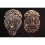 Two Bamileke Kam masks, Cameroon, each covered in strung cowrie shells on a material ground, with