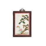 A Chinese famille rose porcelain panel, painted with a hawk perched in a pine tree eyeing a