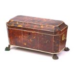 A Regency tortoiseshell and ivory tea caddy, of sarcophagus form on four lion paw feet, with twin