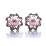 A pair of pearl and diamond earrings, each comprising an 8.7 mm pearl with pink overtones, set on