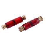 Two Victorian ruby glass double-ended scent bottles; the first has gilt floral terminations,