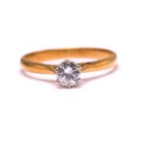 A diamond solitaire ring in 18ct bi-coloured gold, featuring a round brilliant diamond with an