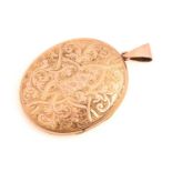 A 9ct gold oval locket, with both covers engraved with foliate and scrollwork details, to reveal two