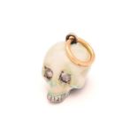 An enamel skull charm pendant with diamonds, a white and mottled teal enamelled silver hollow